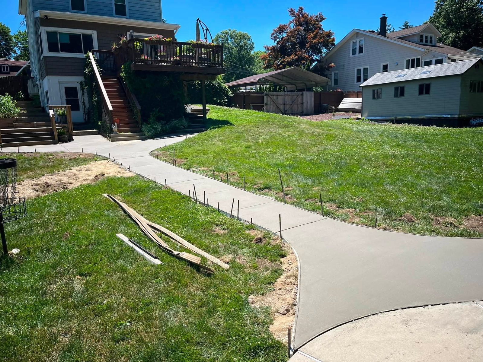 Newly poured backyard walkway with forms still along the edges