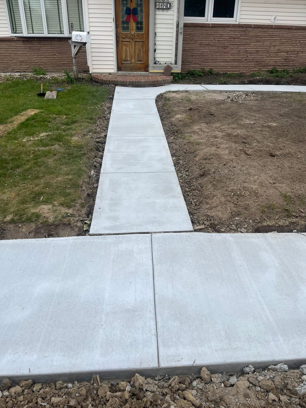 New concrete front walkway leading from the sidewalk to a home's entrance