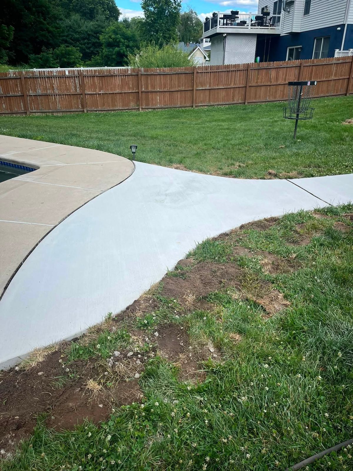 Curved concrete walkway connecting to a pool deck